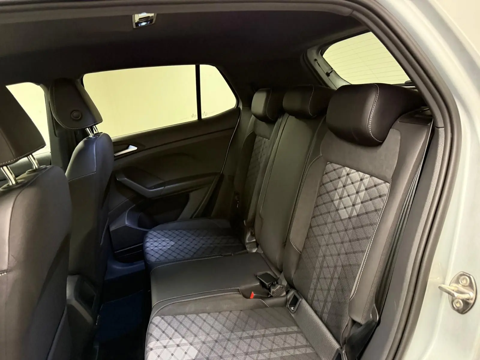Vue intérieure côté droit des sièges arrière en tissu noir à motifs géométriques du Volkswagen T-Cross 2024 finition R-Line.