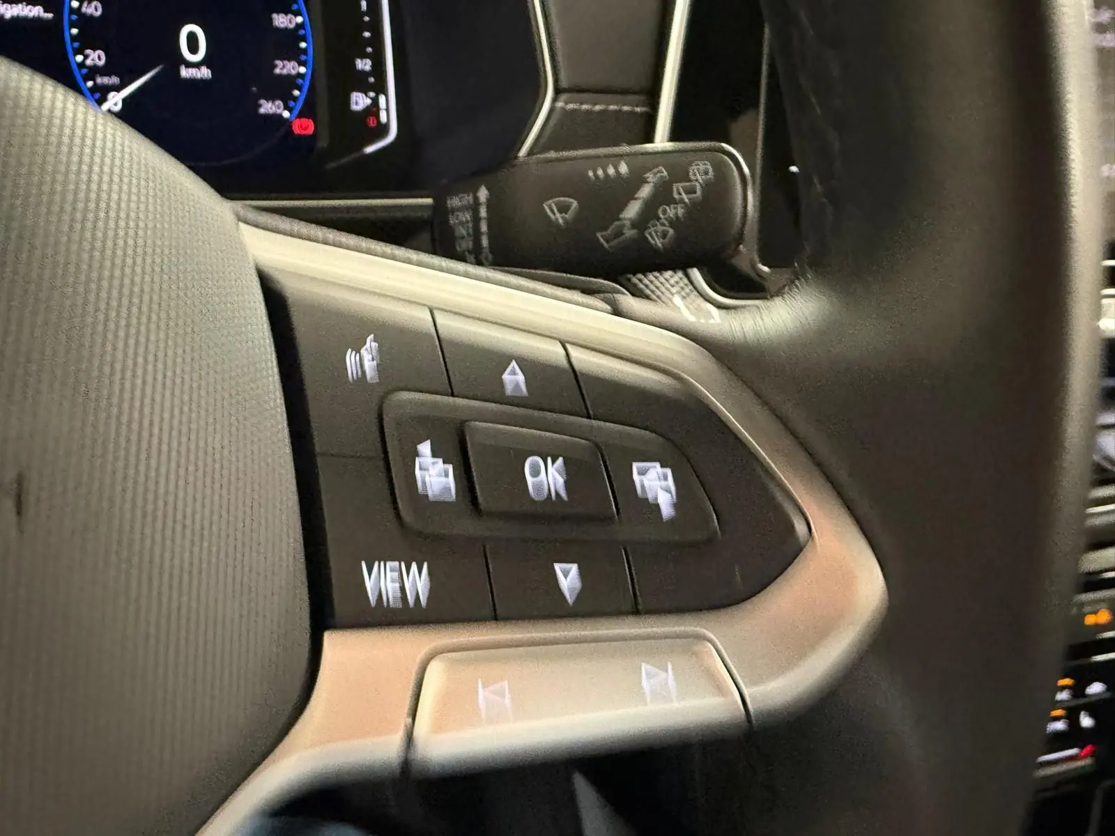 Gros plan sur les commandes multifonctions à gauche du volant du Volkswagen T-Cross 1.5 TSI 150 DSG7 R-Line 2024.