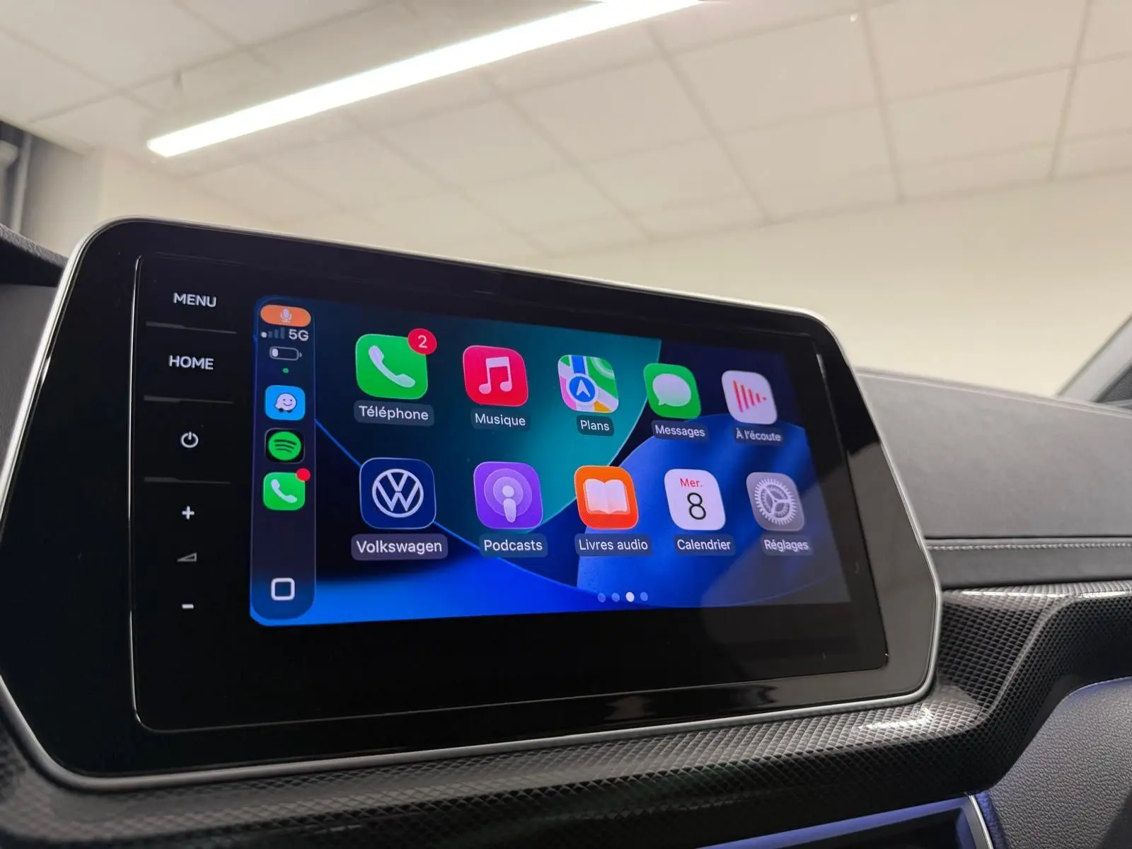 Écran tactile central affichant l'interface Apple CarPlay dans l'habitacle du Volkswagen T-Cross 2024 couleur Reflet d'Argent.
