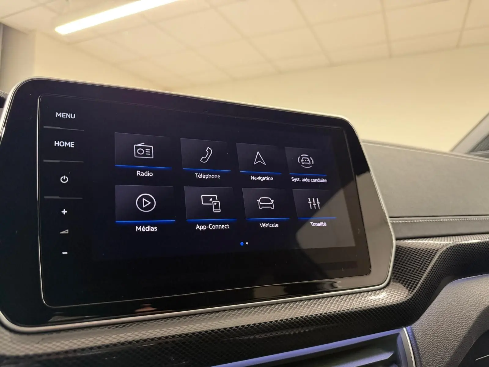 Écran tactile central du Volkswagen T-Cross 1.5 TSI R-Line 2024, affichant le menu principal, intérieur noir.