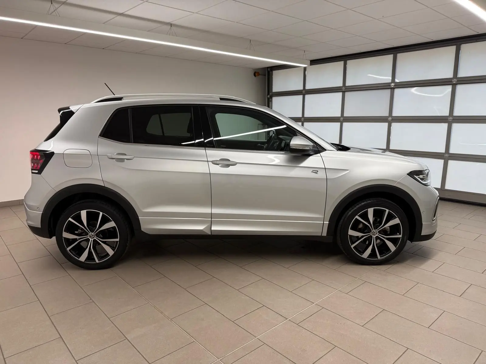Vue de profil côté gauche d'un Volkswagen T-Cross 1.5 TSI R-Line argent métallisé avec jantes alliage 18 pouces.