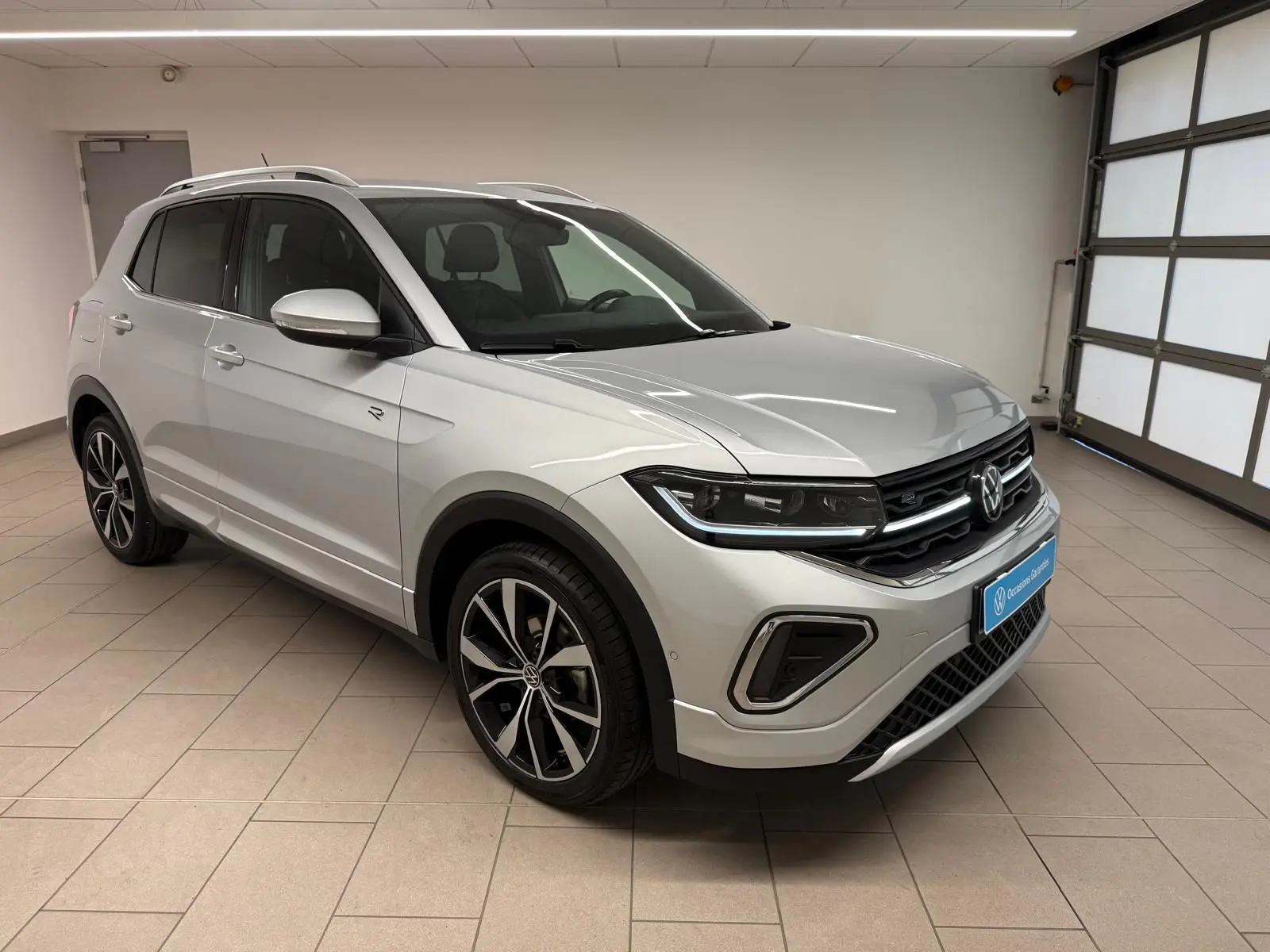 Volkswagen T-Cross 1.5 TSI R-Line en reflet d'argent, vue 3/4 avant droit avec jantes alliage 18 pouces.