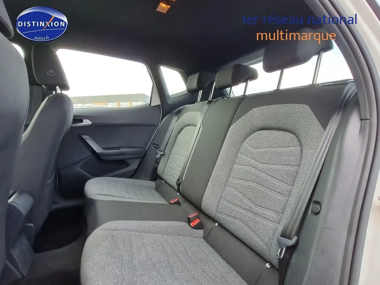 Vue intérieure arrière montrant la banquette grise et noire du SEAT Arona blanc 2023 côté droit.