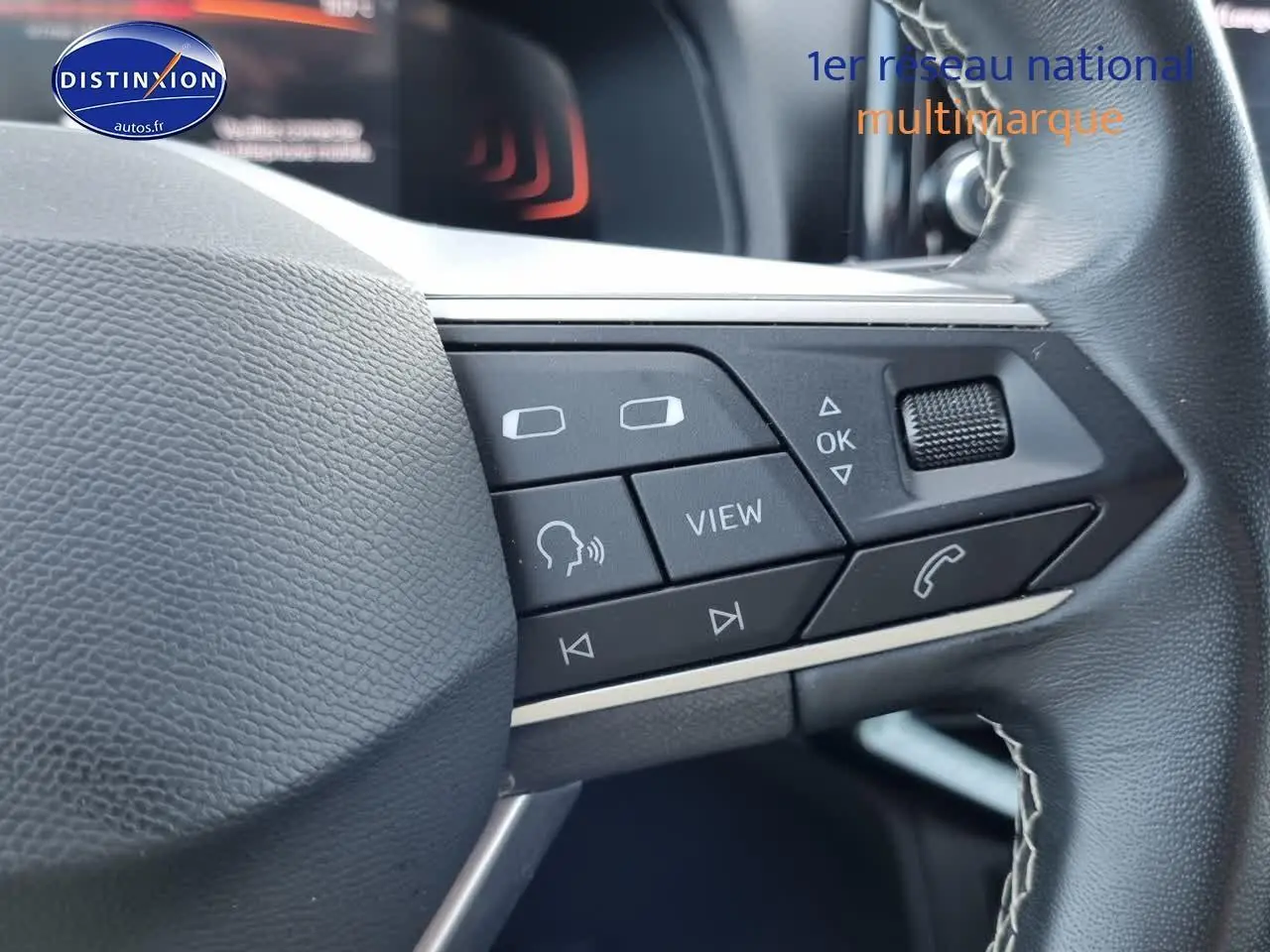 Gros plan sur les commandes multifonctions du volant cuir noir d'une SEAT Arona blanche 2023.