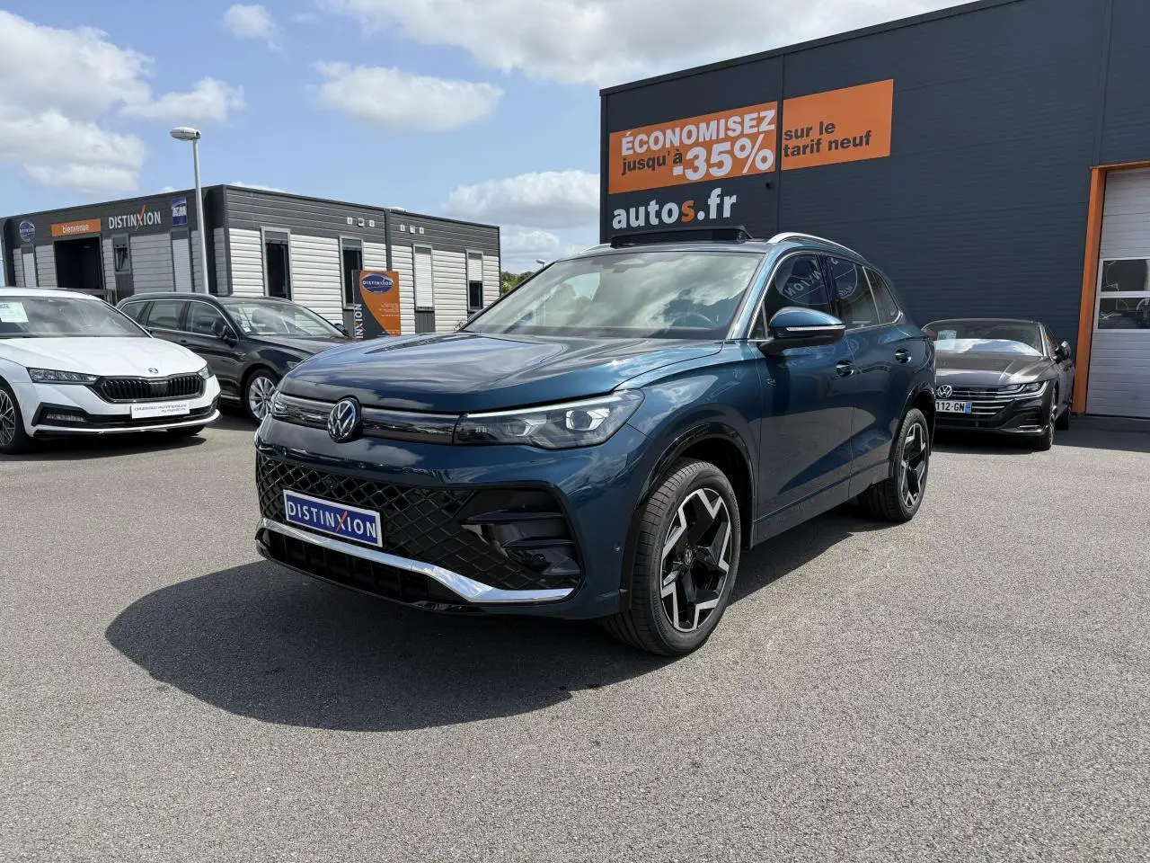 Volkswagen Tiguan 2024 bleu Nightshade en 3/4 avant droit avec jantes R-Line et calandre noire distinctive.