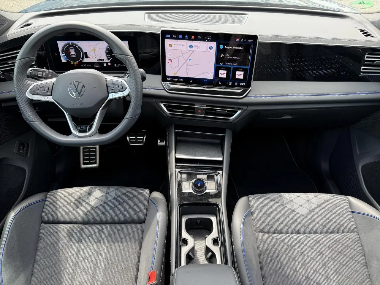 Vue intérieure avant du Volkswagen Tiguan 2024 avec tableau de bord numérique et console centrale moderne.