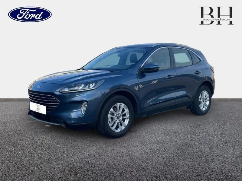 Ford Kuga bleu azur métallisé vu en 3/4 avant droit, avec jantes alu et phares LED allumés.