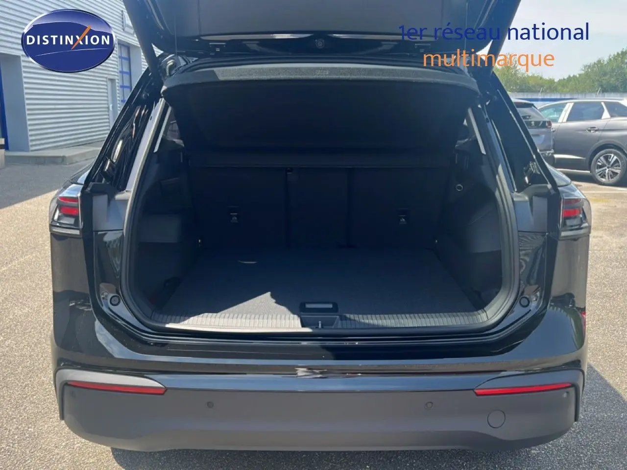 Vue arrière du Volkswagen Tiguan noir Grenadilla métal 2026 avec coffre ouvert et intérieur spacieux visible.