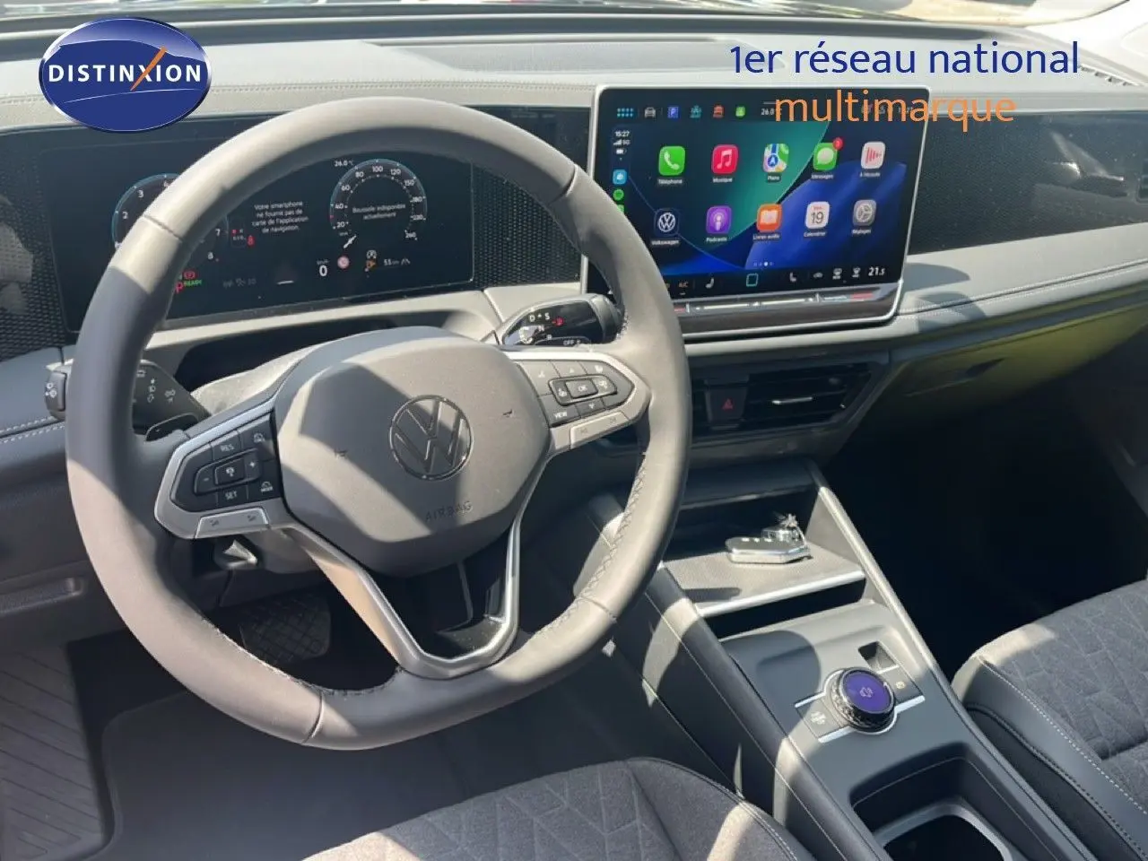 Vue intérieure du volant et tableau de bord du Volkswagen Tiguan 2026 noir avec écran tactile central et commandes au volant.