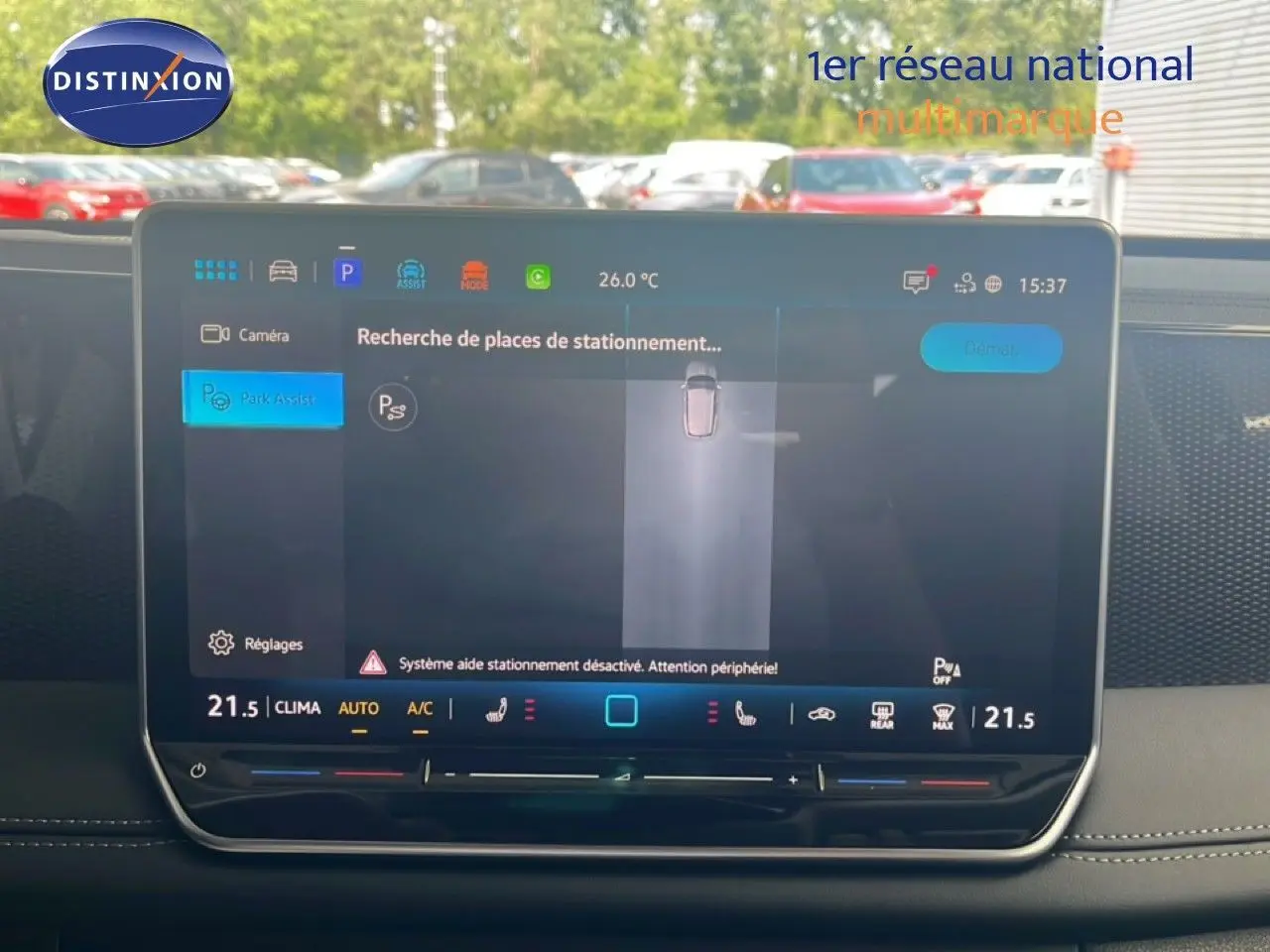 Écran tactile central du Volkswagen Tiguan 2026 affichant l'assistance au stationnement, intérieur noir visible en arrière-plan.