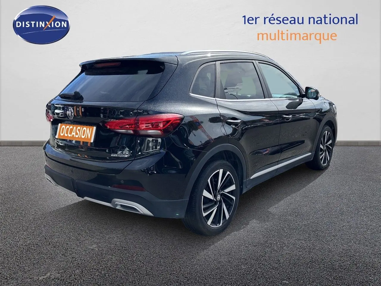 Vue 3/4 arrière droite du MG ZS 1.5L Hybrid+ 197ch Luxury en noir Pebble Black Metal avec jantes alliage bicolores.