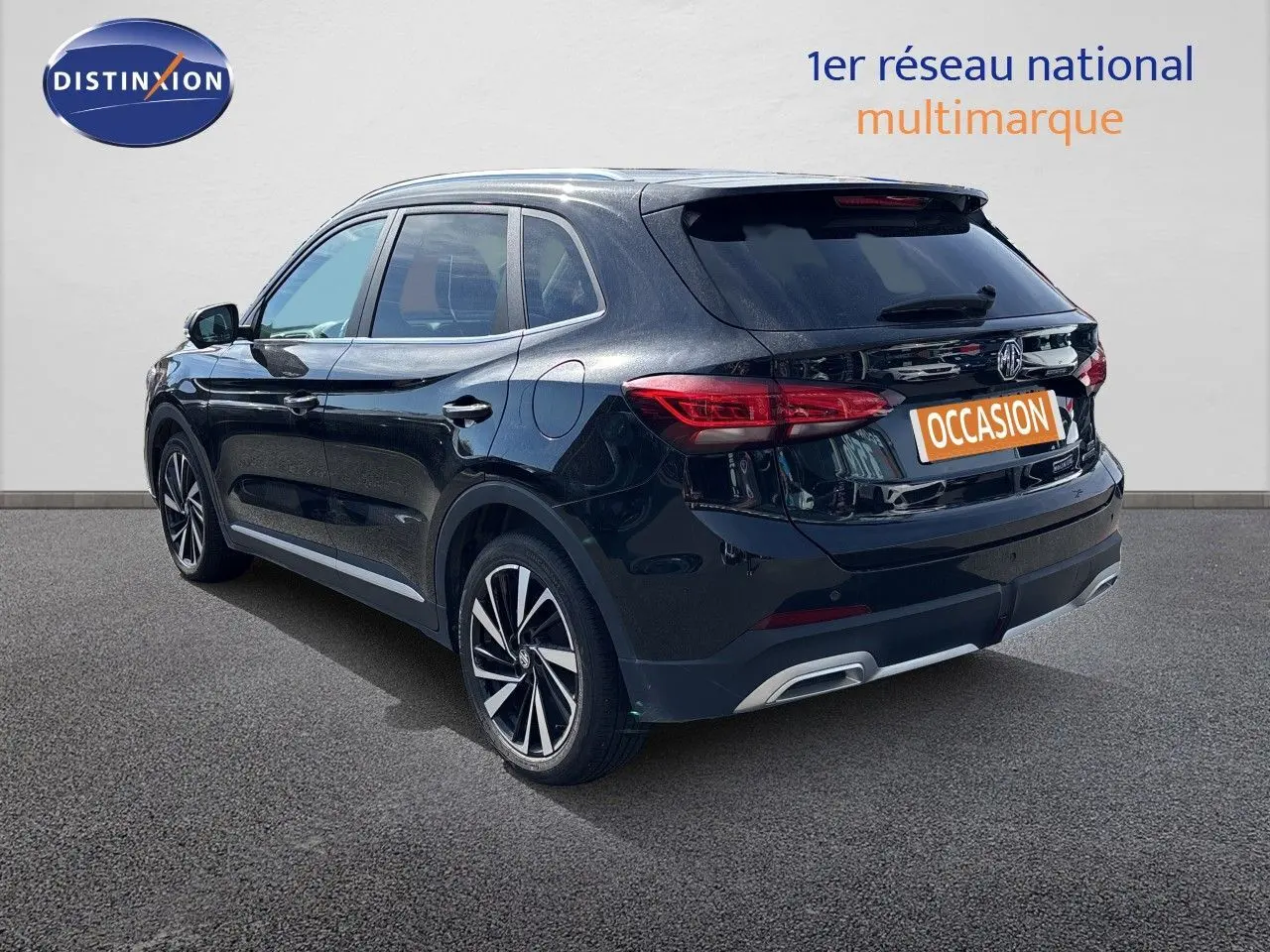Vue 3/4 arrière droite du MG ZS 1.5L Hybrid+ 197ch Luxury en Pebble Black Metal avec jantes alliage bicolores.