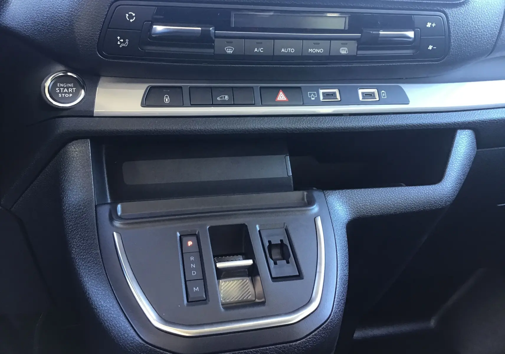 Gros plan sur la console centrale du Peugeot Expert Fourgon blanc 2024, avec bouton start/stop et commandes climatisation.