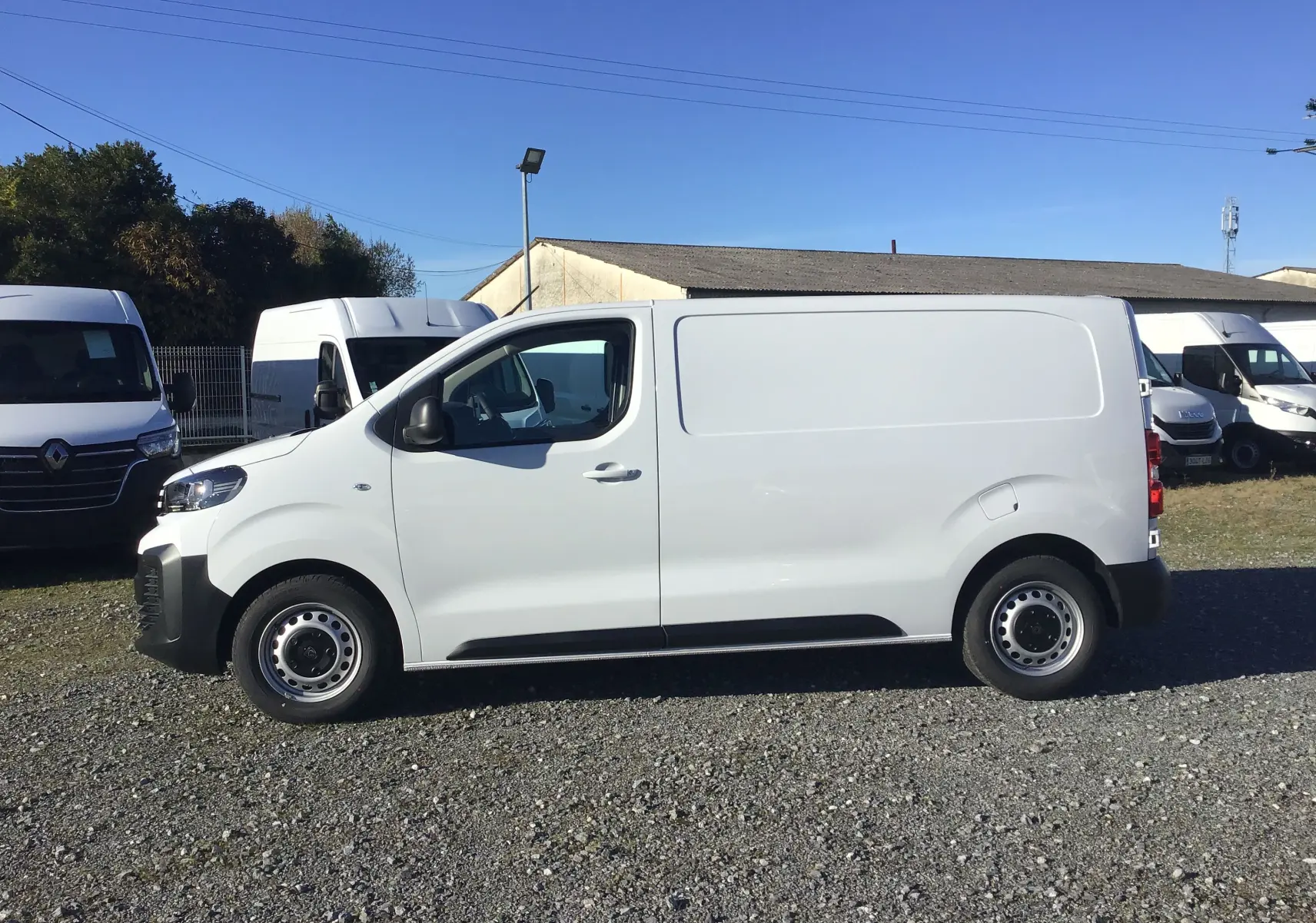 Vue de profil côté gauche d'un Peugeot Expert Fourgon blanc 2024, avec une carrosserie lisse et des jantes acier simples.