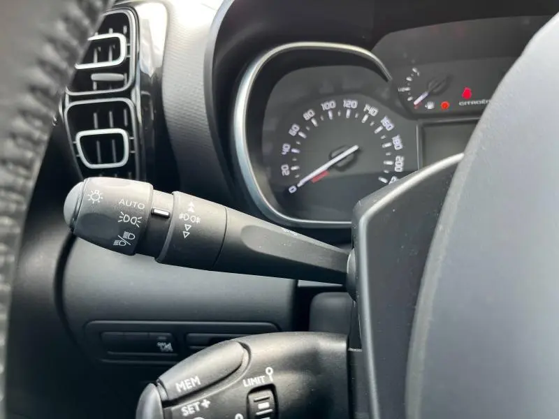 Gros plan sur la commande des phares et le compteur partiel du tableau de bord du Citroën C3 Aircross gris acier 2020.