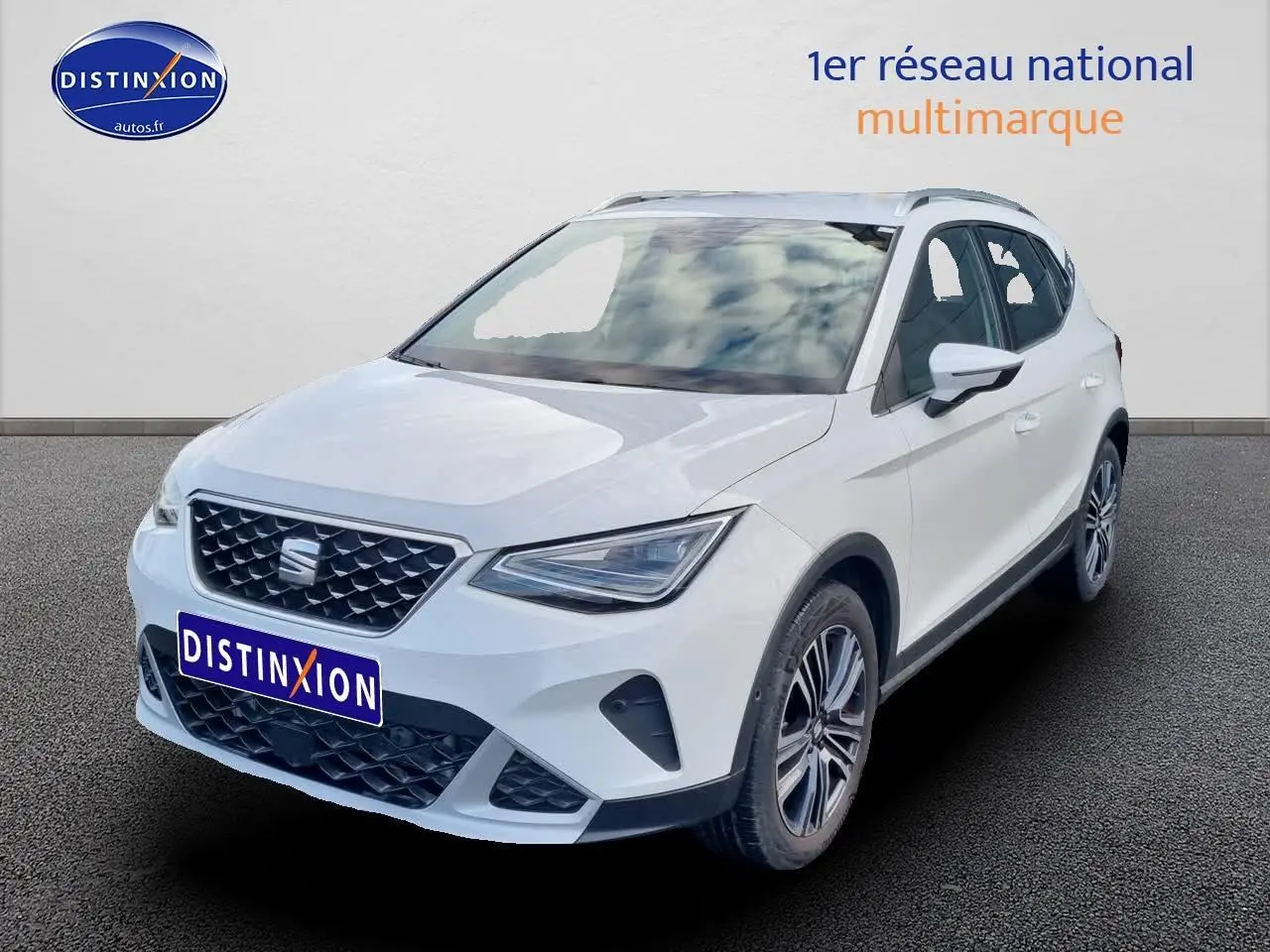 SEAT Arona blanc vue 3/4 avant droit, avec jantes alu et barres de toit visibles sur fond neutre.