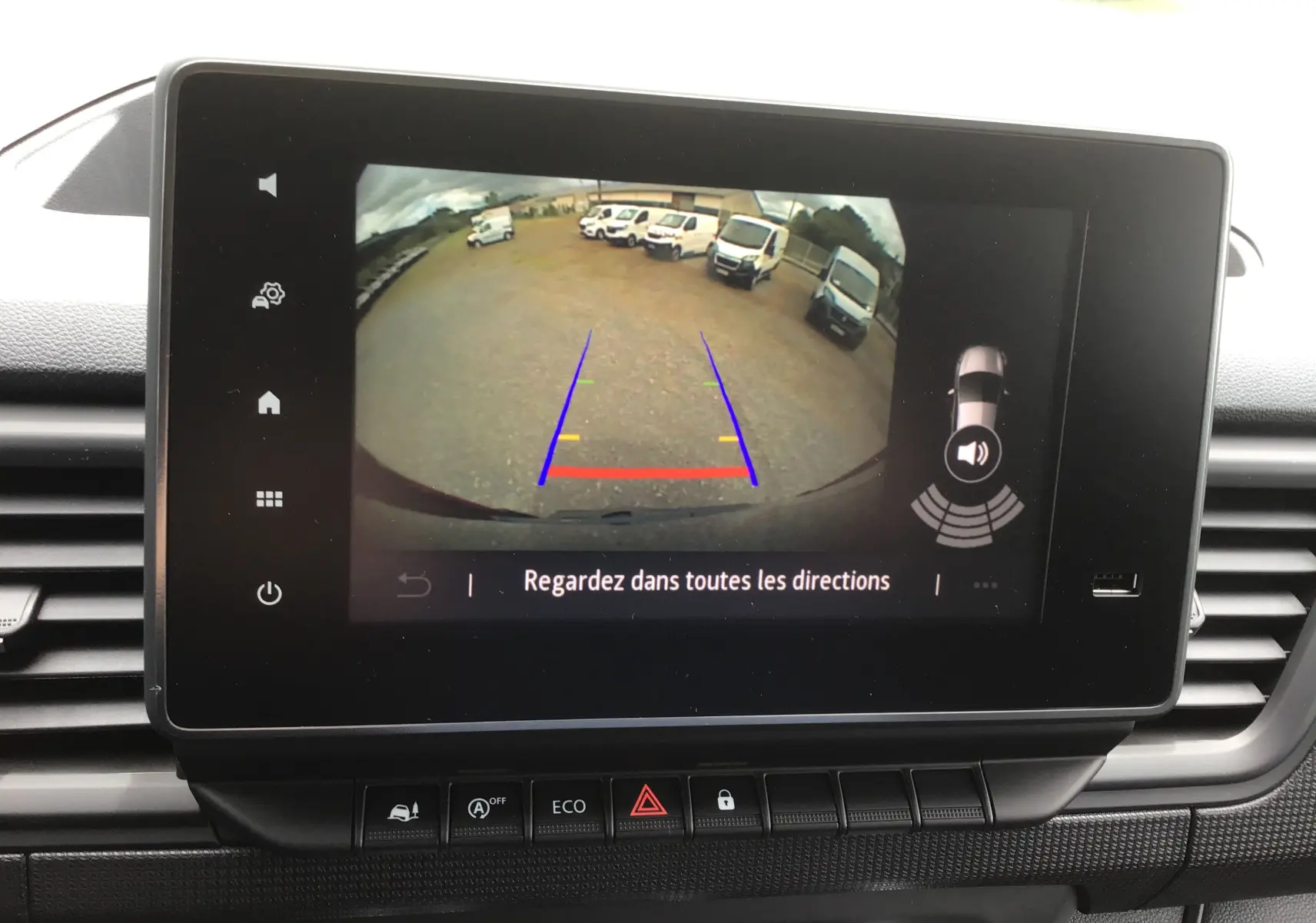 Écran tactile intérieur montrant la caméra de recul du Renault Trafic Fourgon gris comète, avec lignes de guidage colorées.