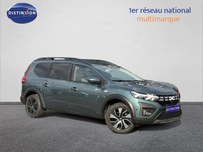 Vue 3/4 avant droit d'un Dacia Jogger 2025 Vert Cèdre métallisé avec jantes noires et toit noir contrasté.