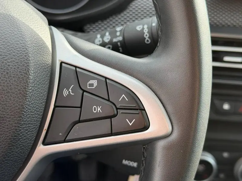 Gros plan sur les commandes au volant côté gauche du Dacia Jogger 2025, avec finition noire et contour argenté.