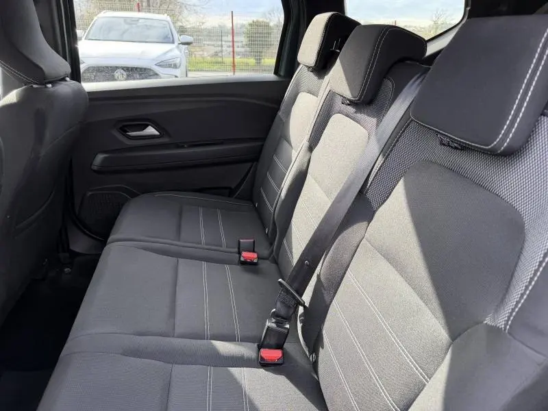 Vue intérieure sur la banquette arrière grise du Dacia Jogger 2025, montrant les sièges 7 places et les ceintures de sécurité.