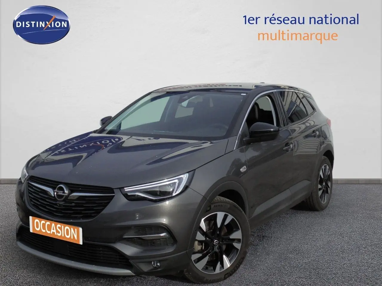 Opel Grandland X gris Moai Metal en 3/4 avant droit, SUV hybride rechargeable avec jantes noires distinctives.