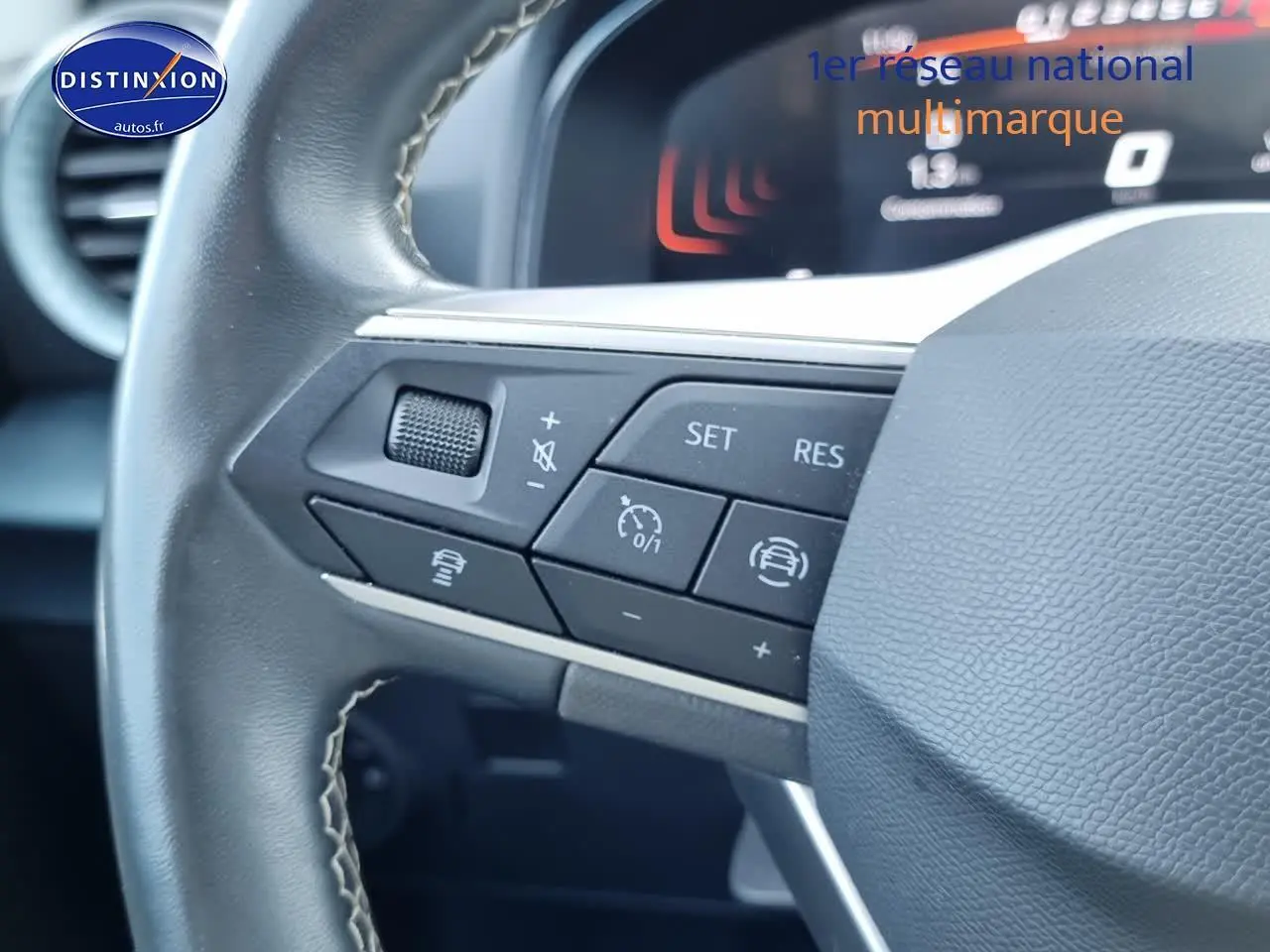 Gros plan sur les commandes multifonctions du volant cuir du SEAT Arona blanc 2023, avec affichage numérique en arrière-plan.