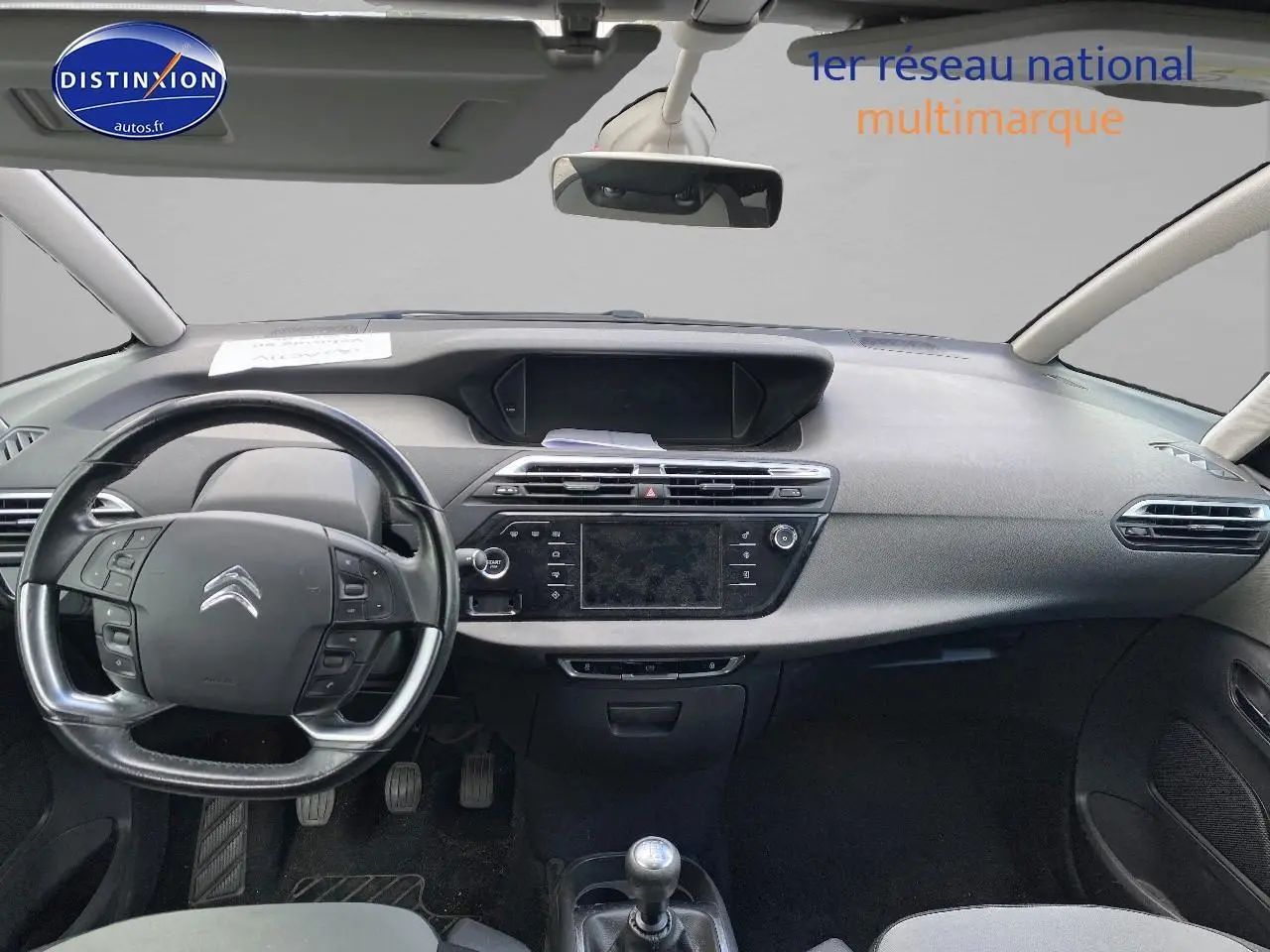 Intérieur avant d'une Citroën C4 Picasso gris, volant multifonction et tableau de bord avec écran tactile central.