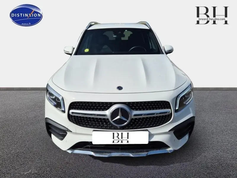 Vue frontale d'un Mercedes GLB 200 d AMG Line blanc polaire avec calandre chromée et phares LED distinctifs.