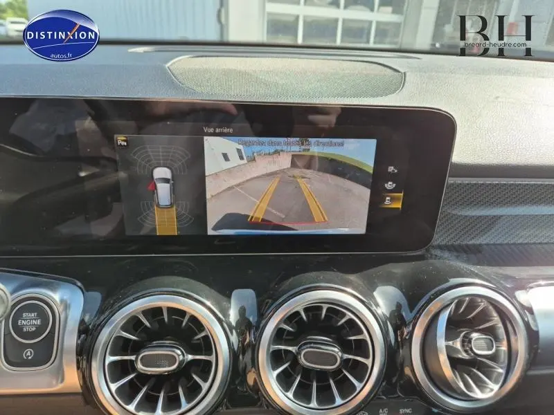 Écran tactile intérieur du Mercedes GLB 200 d 2023 montrant la caméra de recul avec vue arrière et aides au stationnement.