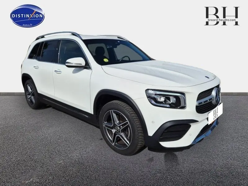 Mercedes GLB 200 d AMG Line blanc polaire vue 3/4 avant droit avec jantes alliage et barres de toit noires.