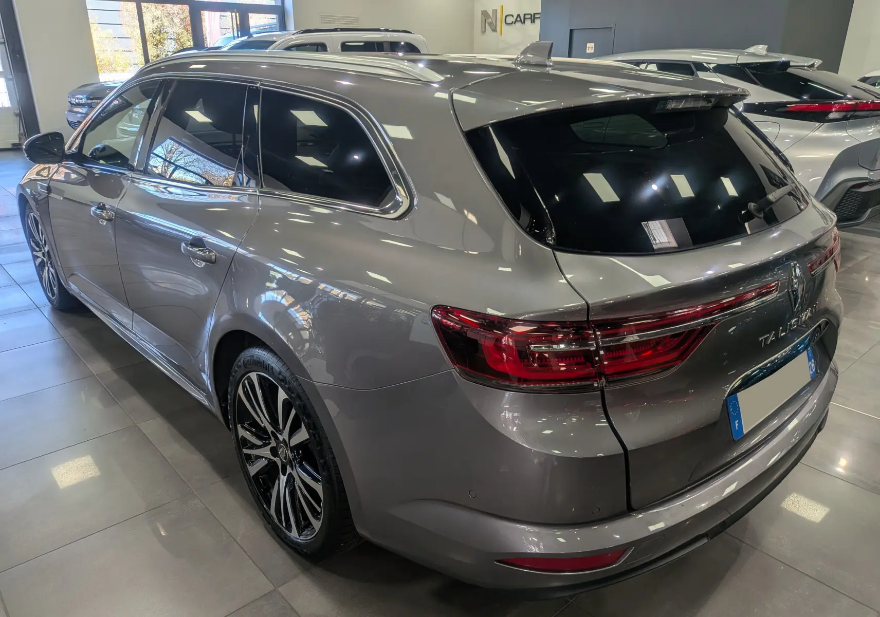 Renault Talisman Estate gris Cassiopé en 3/4 arrière droit, avec feux arrière LED et jantes alliage bicolores.