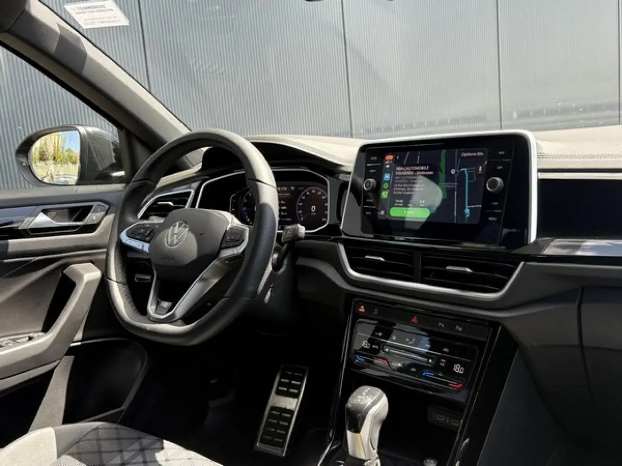 Vue intérieure côté conducteur du Volkswagen T-Roc 1.5 TSI R-Line 2025, avec volant cuir multifonction et écran tactile central.