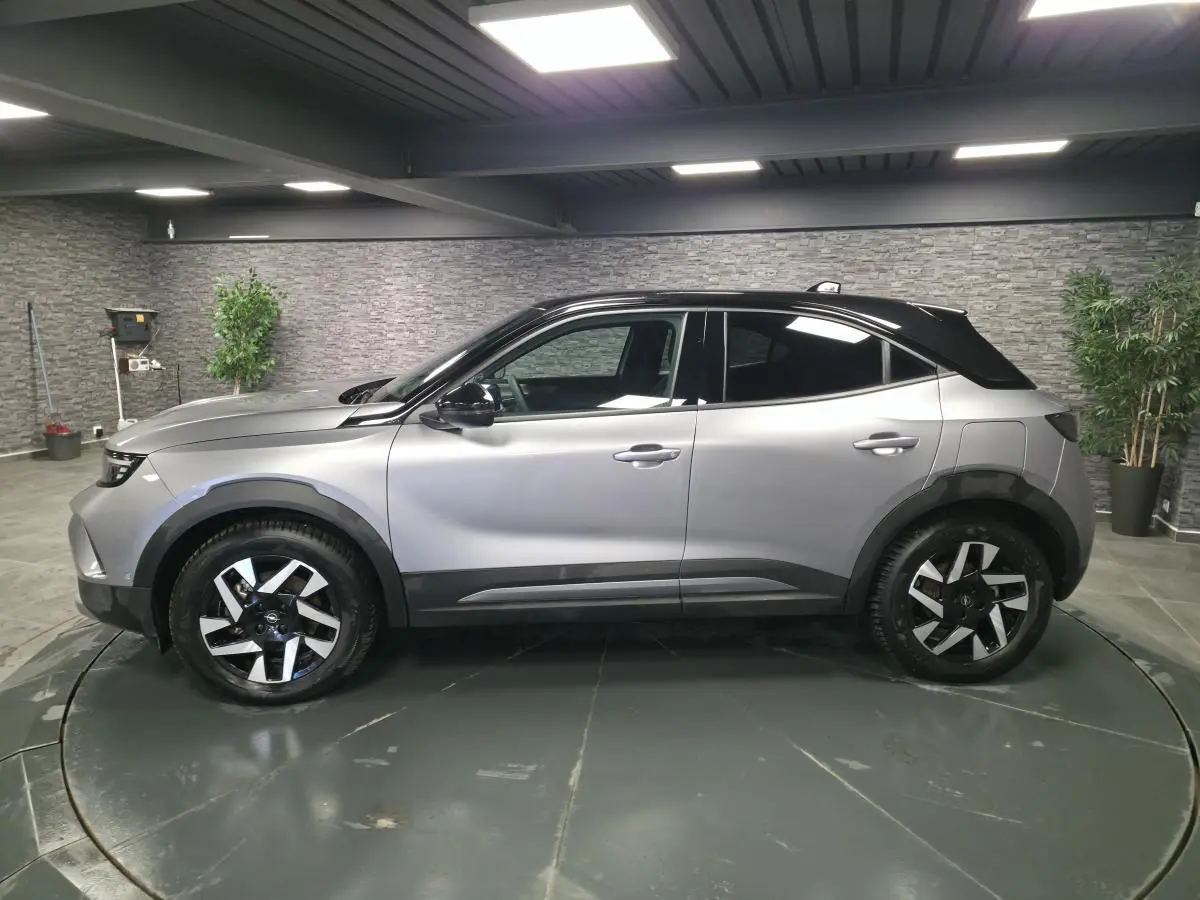 Opel Mokka-e 2025 gris avec toit noir, vue de profil côté gauche, jantes alliage diamantées 17 pouces.