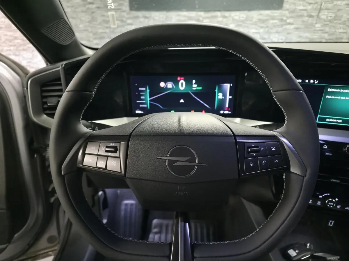 Vue rapprochée du volant noir de l’Opel Mokka-e 2025 avec tableau de bord digital et commandes intégrées.