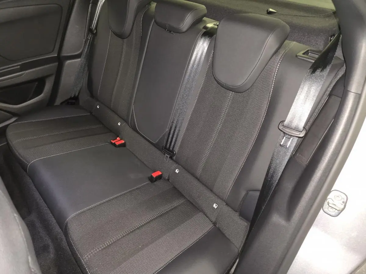 Vue rapprochée de la banquette arrière noire de l'Opel Mokka-e 2025 avec ceintures et appuie-têtes intégrés.