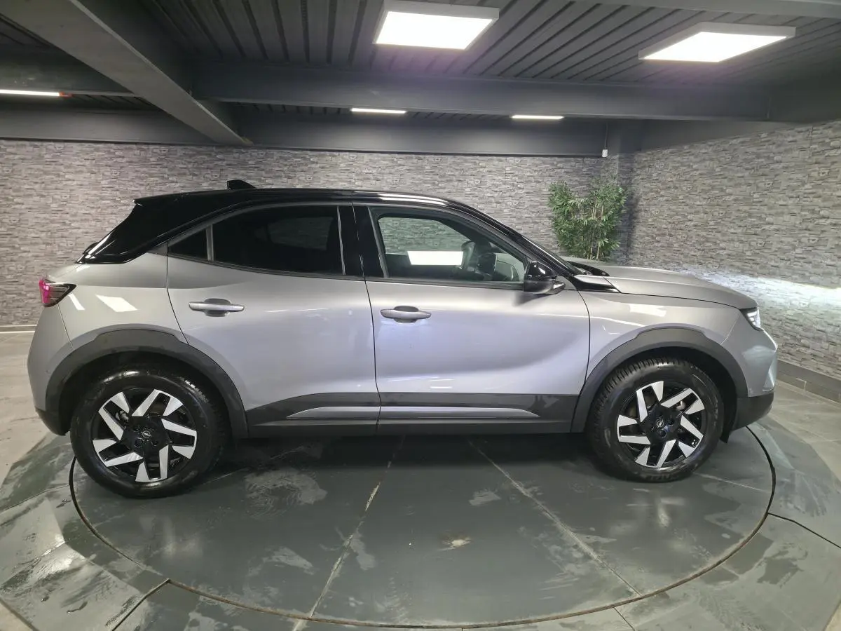 Opel Mokka-e 2025 gris, vue de profil côté gauche, avec toit noir et jantes alliage diamantées 17 pouces.