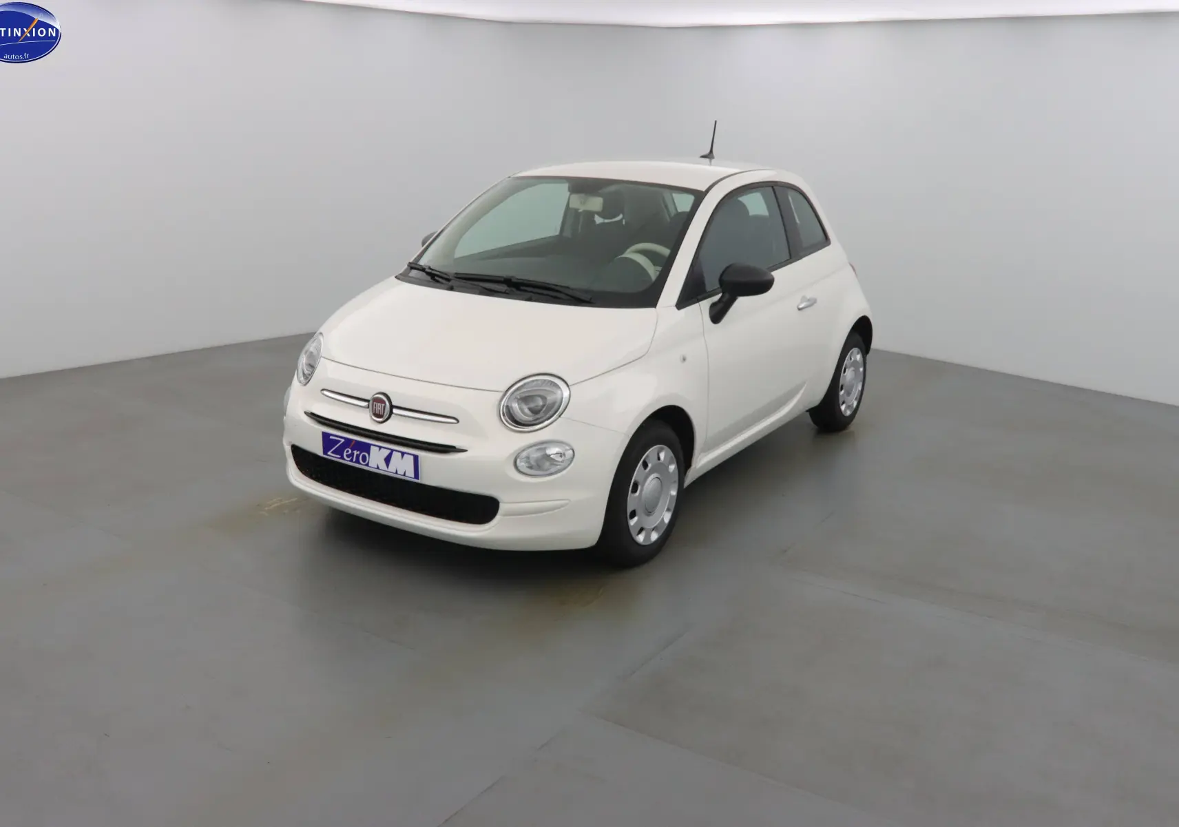 Vue 3/4 avant d'une FIAT 500 blanche Gelato, compacte avec phares ronds et rétroviseurs noirs.