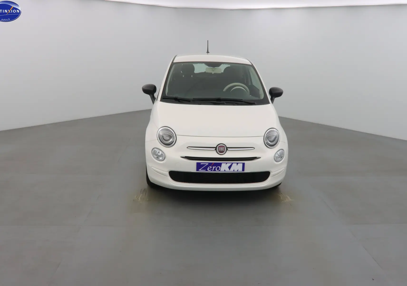 Vue frontale d'une Fiat 500 blanche Gelato 2023 avec phares ronds et logo Fiat central visible.