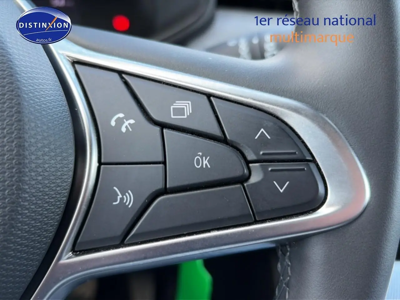 Gros plan sur les commandes multifonctions noires du volant de la Renault Clio V gris métal, avec contour argenté.