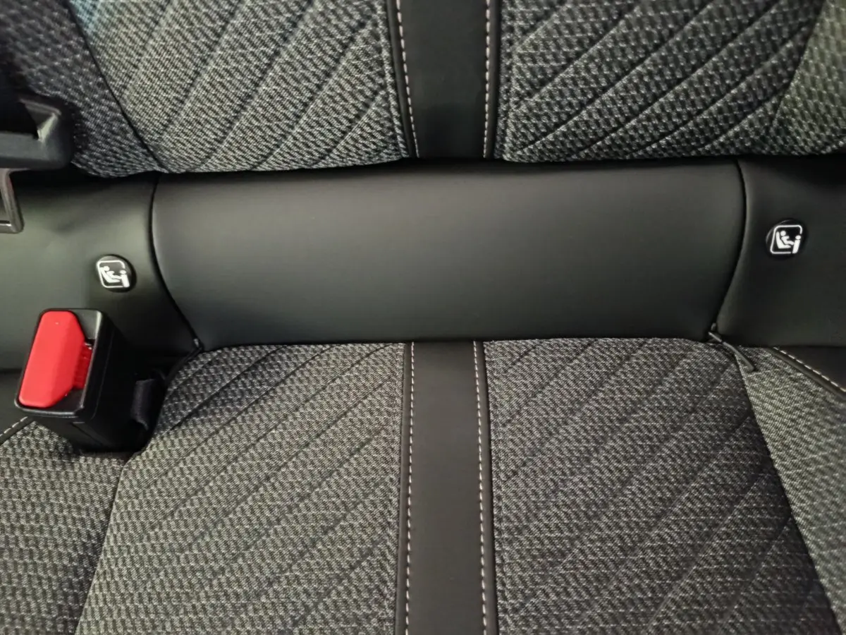 Détail de la banquette arrière gris foncé de la Peugeot 208 PureTech 100 S&S Allure avec ceinture de sécurité rouge.