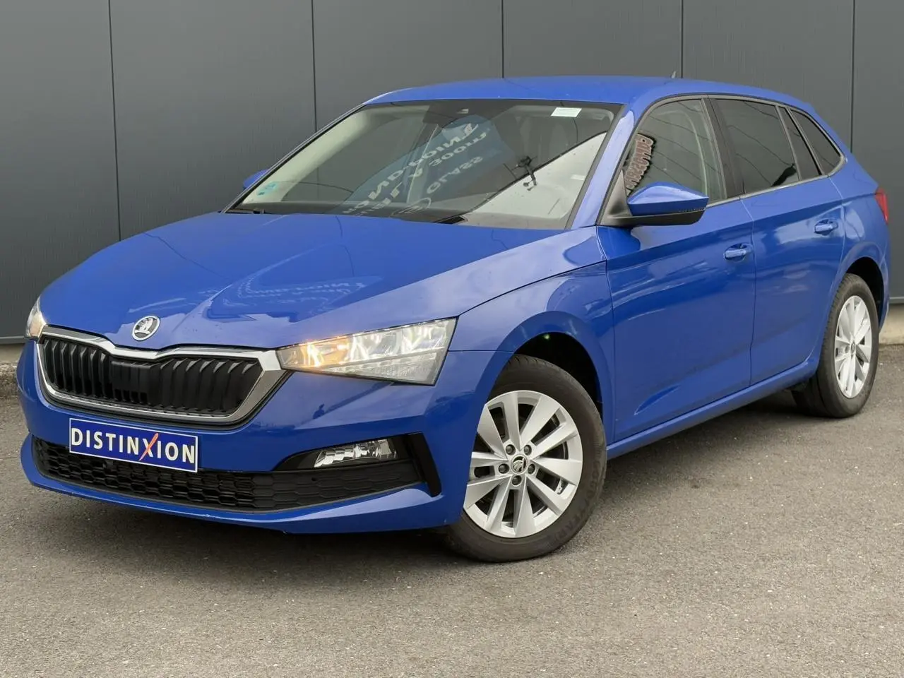 Vue 3/4 avant droite d'une Skoda Scala bleu Energy avec jantes alliage argent et calandre noire distinctive.