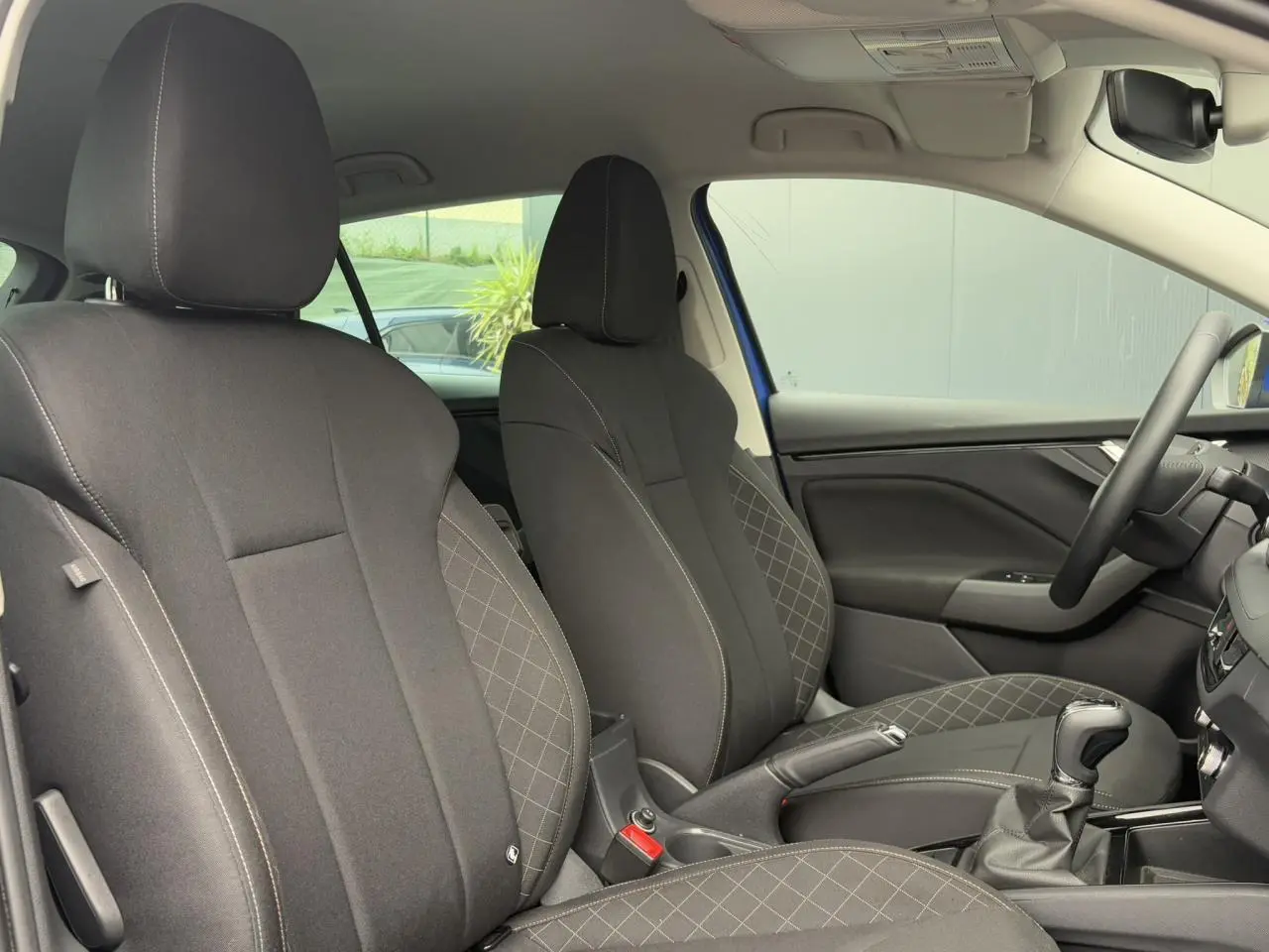 Intérieur de la Skoda Scala TSI 110 DSG Ambition 2024 en bleu Energy, vue côté droit sur sièges noirs et console centrale.