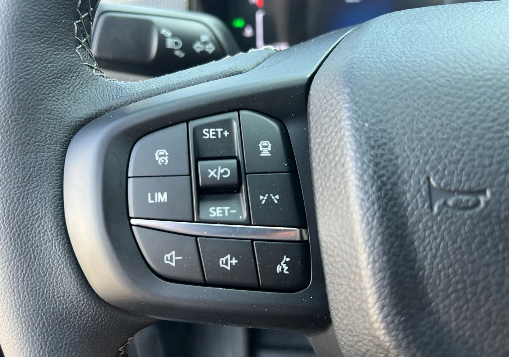 Gros plan sur les commandes multifonctions au volant noir du Ford Ranger 2025 gris iconic, version Tremor Cover.