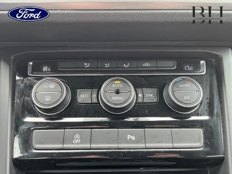 Gros plan sur la console de climatisation noire du Volkswagen Touran 2.0 TDI 122ch avec commandes rotatives et écran digital.