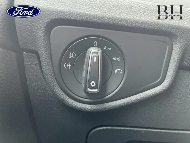 Commande rotative des phares sur tableau de bord noir d'un Volkswagen Touran 2.0 TDI 2021, vue rapprochée