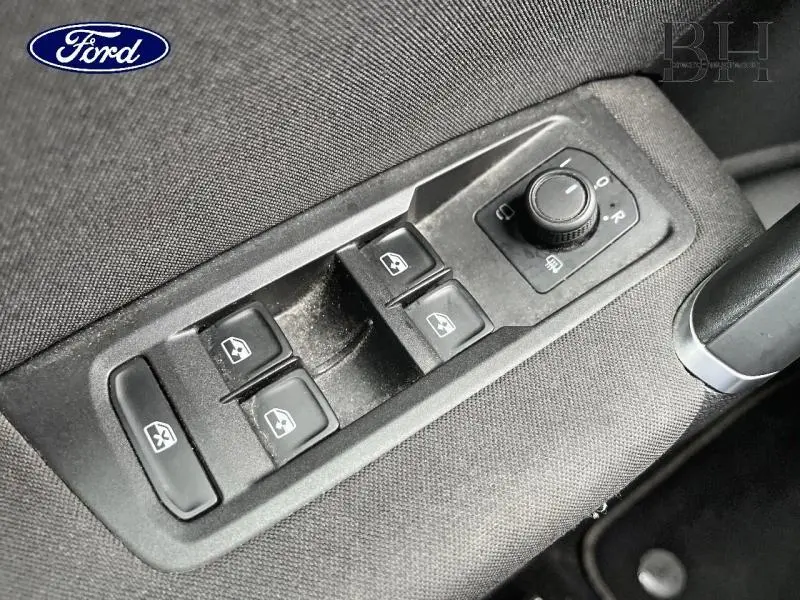 Gros plan sur les commandes des vitres électriques et réglage des rétroviseurs du Volkswagen Touran noir intense nacré.