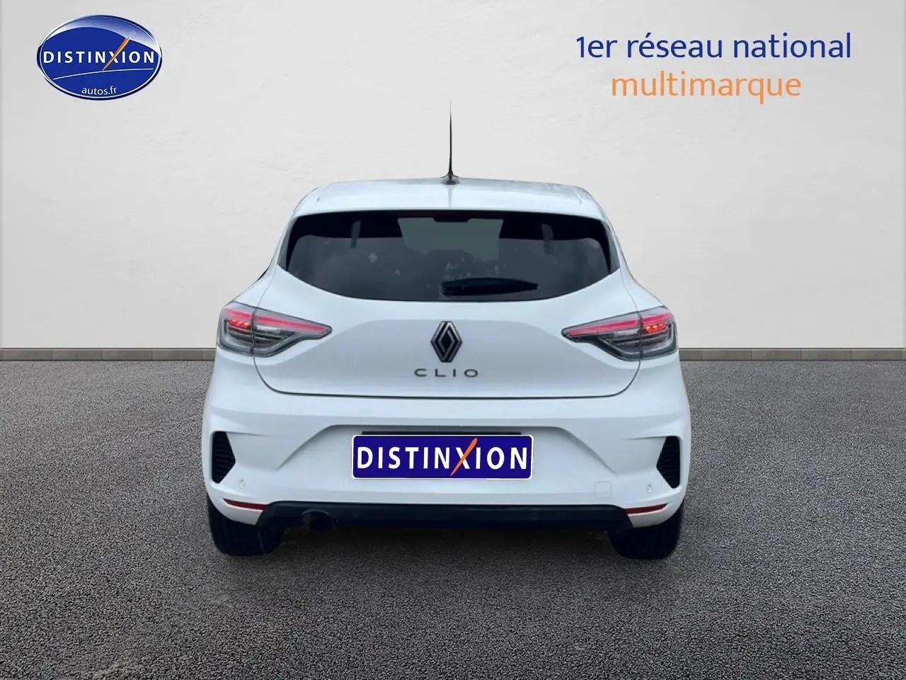 Vue arrière d'une Renault Clio V blanche avec feux arrière LED et logo Renault bien visible.