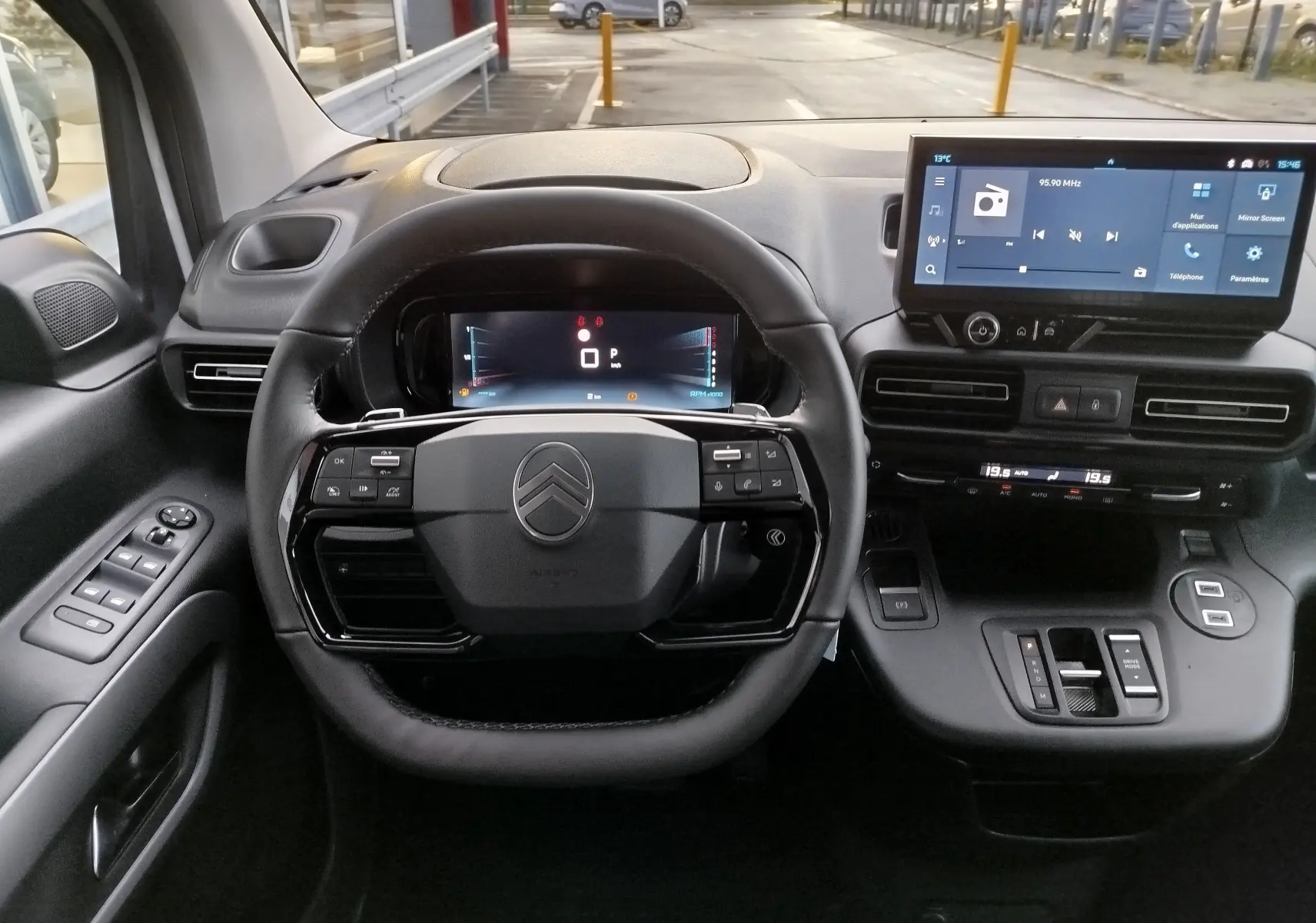 Vue intérieure du poste de conduite du Citroën Berlingo 2025, tableau de bord noir avec écran tactile et volant multifonction.