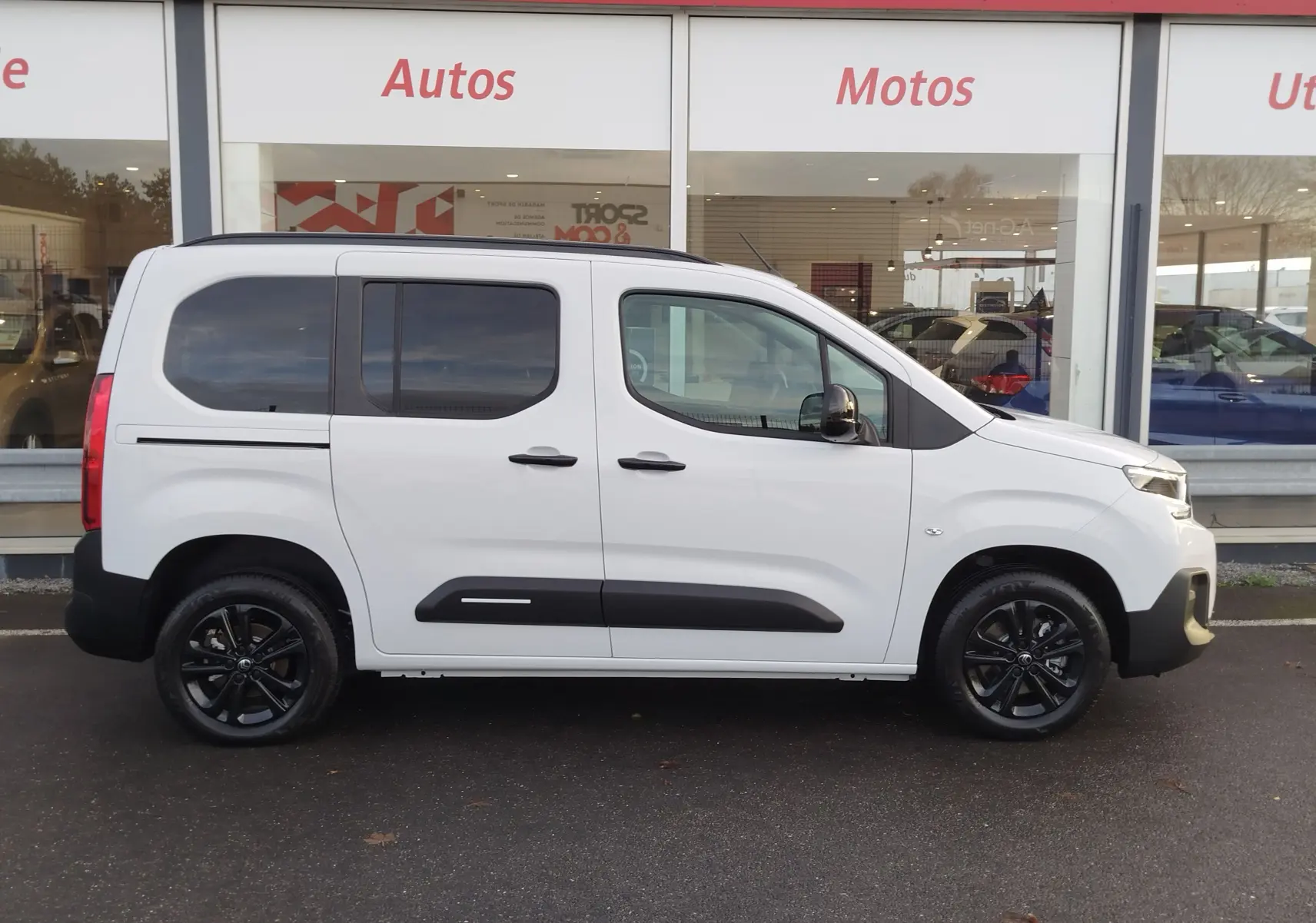 Vue de profil droit du Citroën Berlingo Kaolin White 2025 avec jantes noires et vitres teintées.