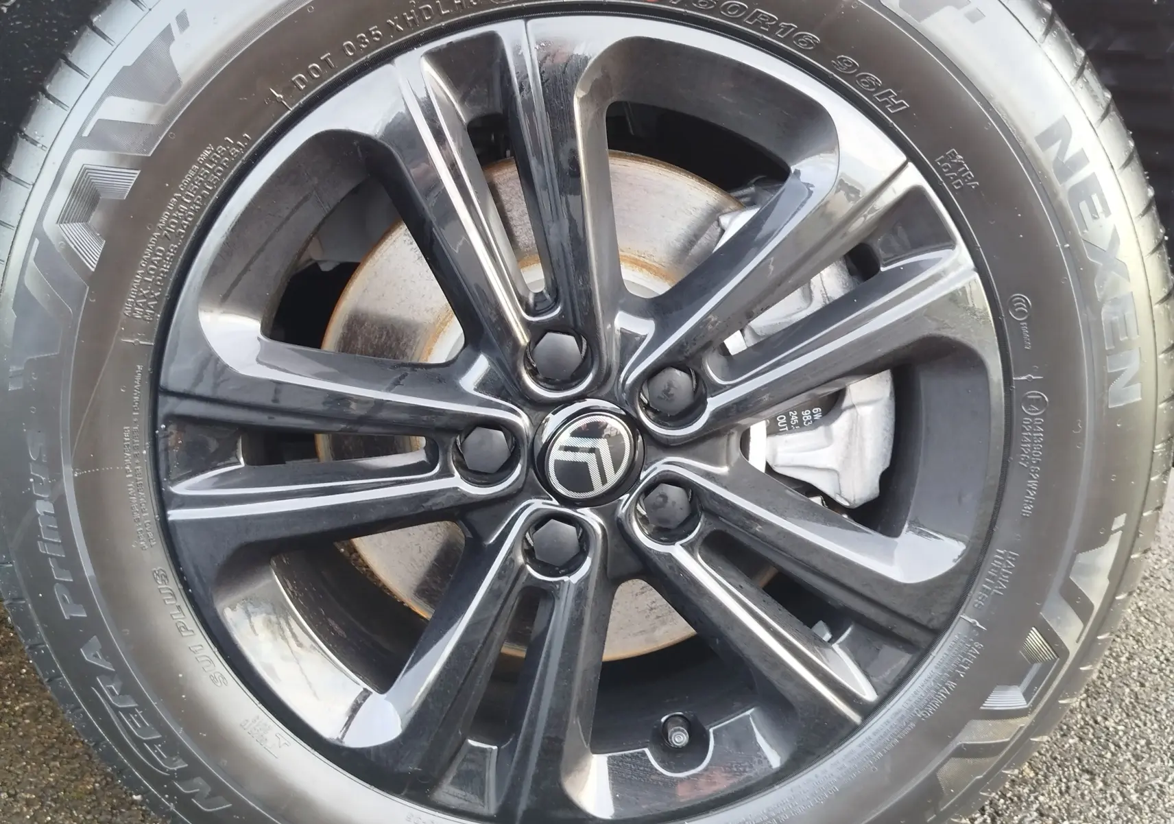 Gros plan sur la jante noire brillante avec logo Citroën au centre, montée sur pneu Nexen visible en extérieur.